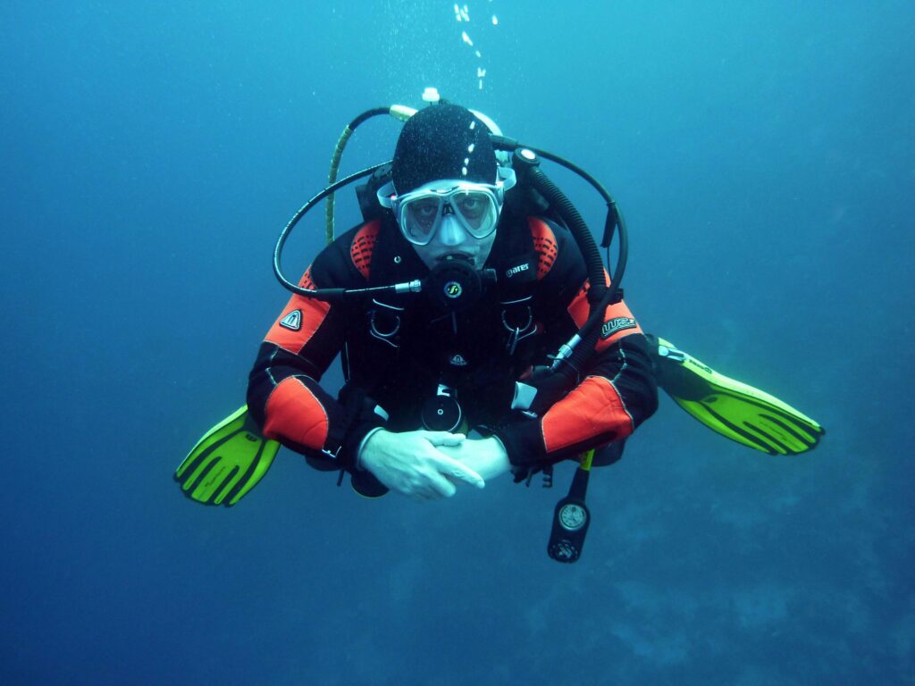 divers-scuba-divers-diving-underwater-37530-37530 A diver in a drysuit exploring the ocean depths with full scuba gear.