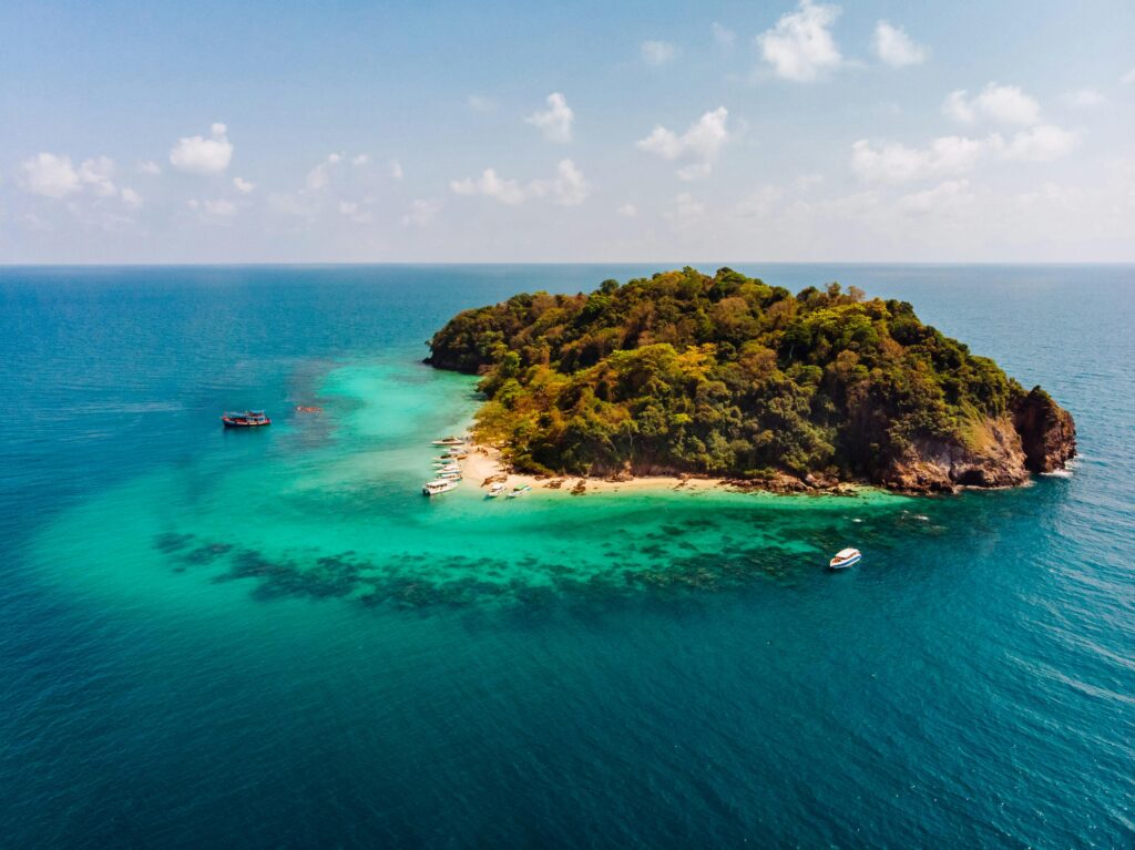 Discover the untouched beauty of a tropical island surrounded by crystal-clear waters from an aerial perspective.