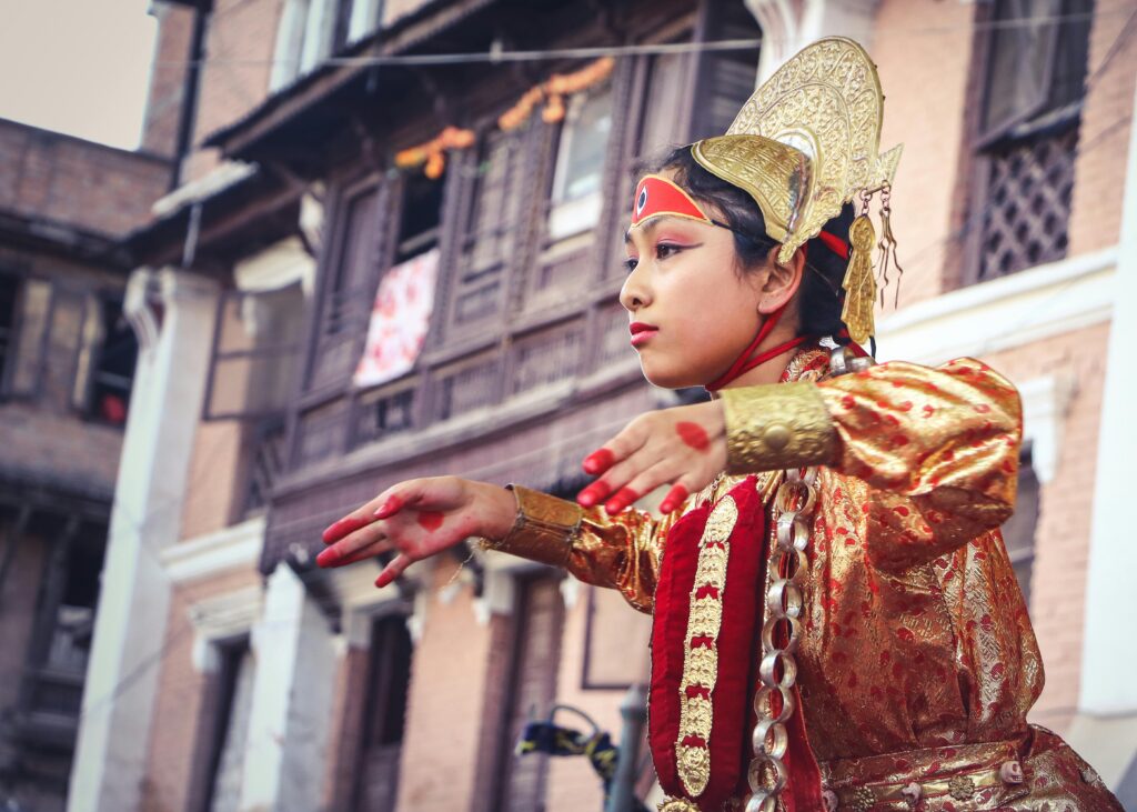 pexels-photo-1274922-1274922 Young girl in vibrant traditional wear dancing at a Nepali festival.