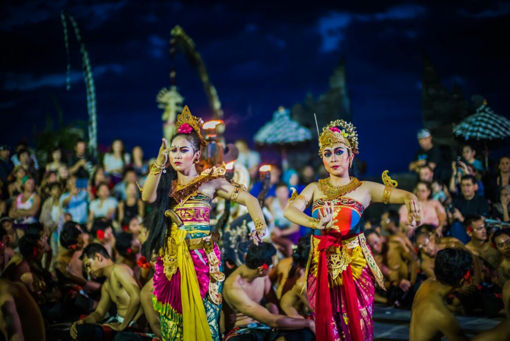 pexels-photo-1477310-1477310-1 Two women perform traditional Balinese dance in colorful costumes during a festival.