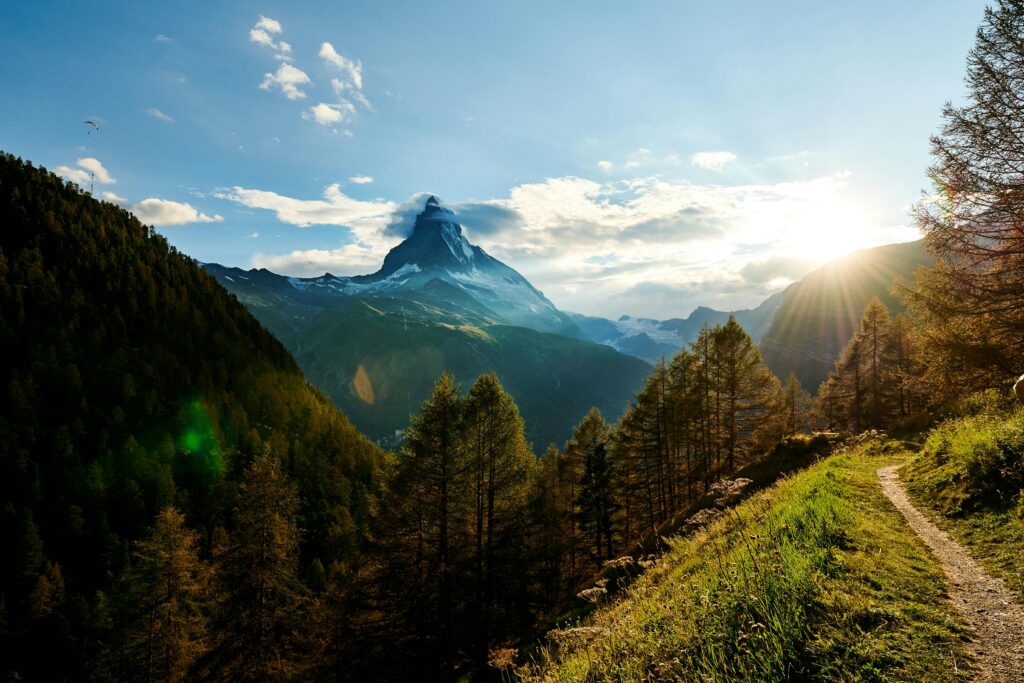 pexels-photo-1659436-1659436 Sunrise over Matterhorn mountain with scenic views of lush greenery and clear blue skies.