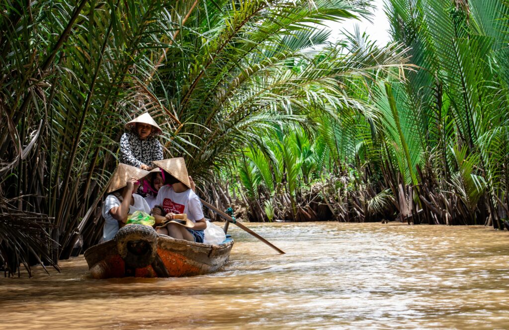 pexels-photo-1660996-1660996 Explore the vibrant scenery on a traditional boat ride through the Mekong Delta's palm-lined waterways.