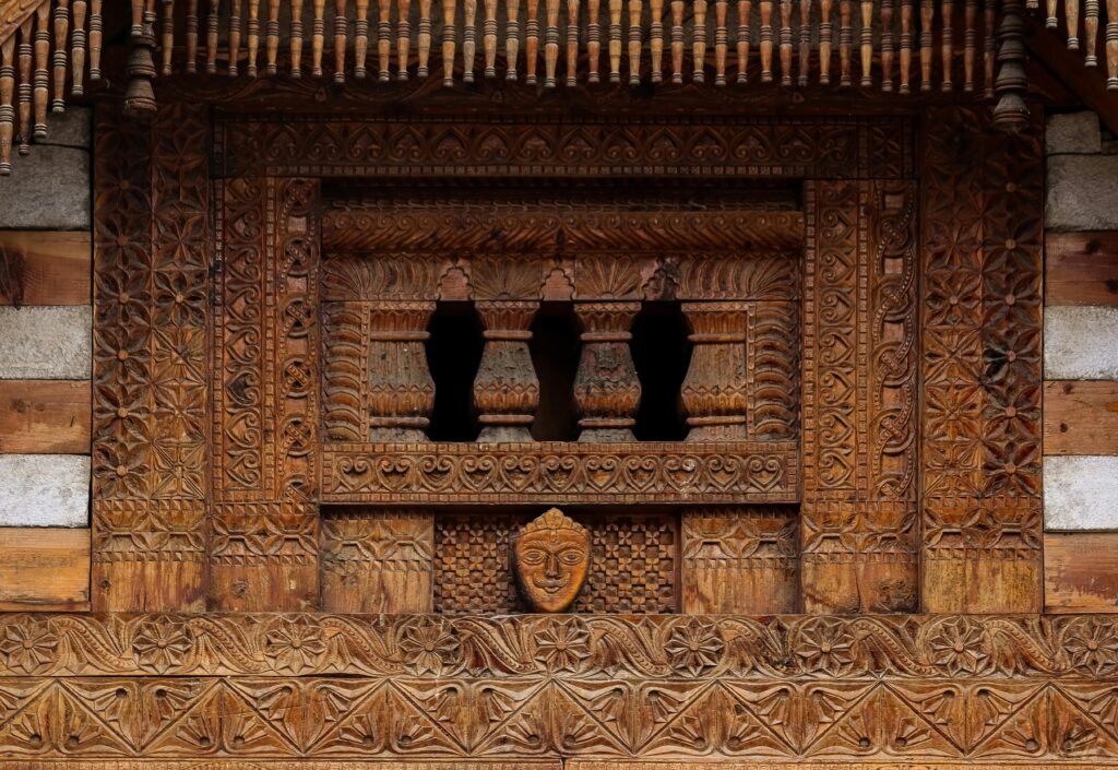 Detailed wooden carving on a traditional Indian temple facade, showcasing ancient architecture.