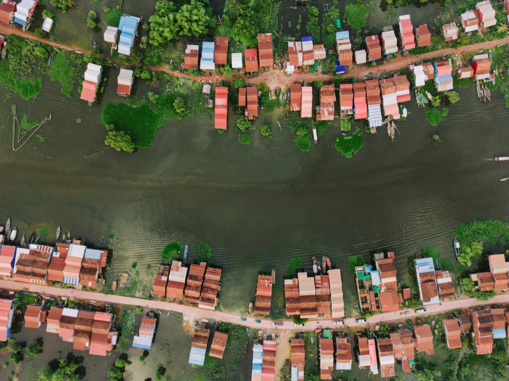 pexels-photo-19063392-19063392 Aerial view of Kampong Khleang floating village and its stilt houses on a vibrant waterway.