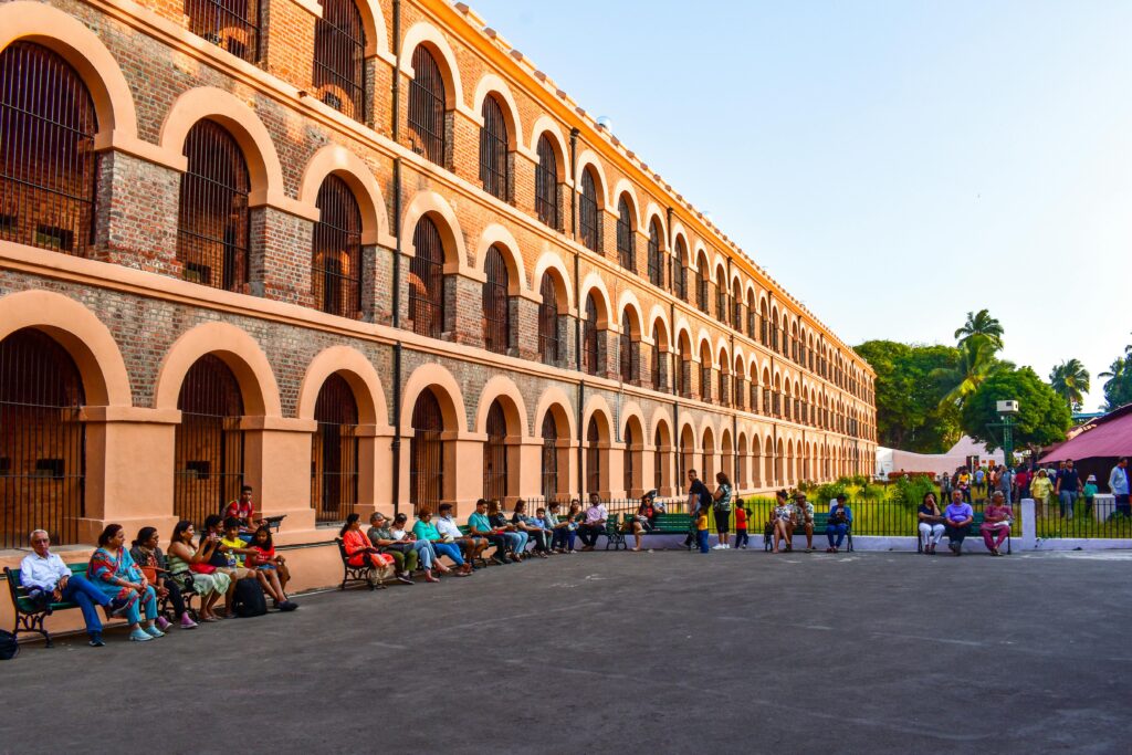 pexels-photo-19755206-19755206 People gathered outside the historic Cellular Jail with its distinctive arched windows and barred architecture.