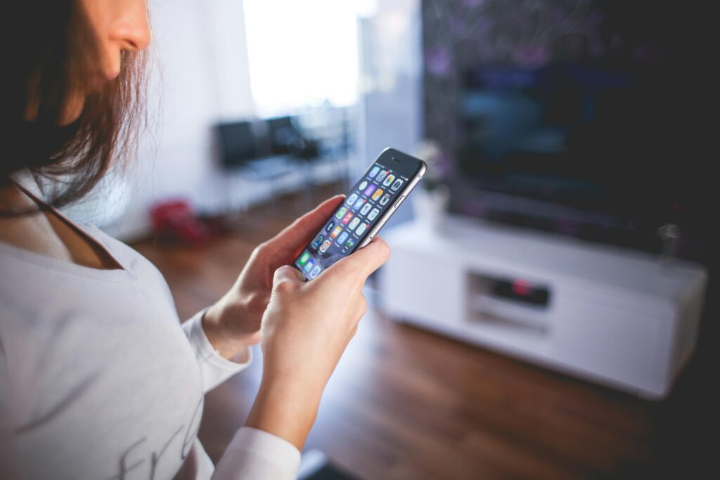 pexels-photo-225232-225232 Woman browsing smartphone indoors, highlighting modern technology and communication in a cozy home setting.