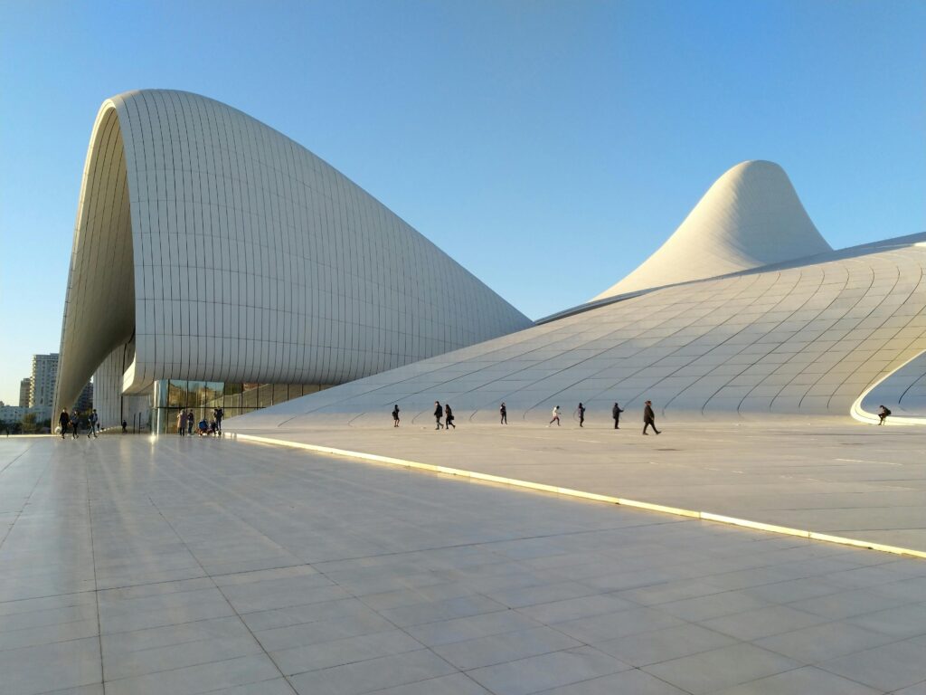 pexels-photo-2716795-2716795 Striking modern architecture of the Heydar Aliyev Center in Baku with people walking under clear skies.