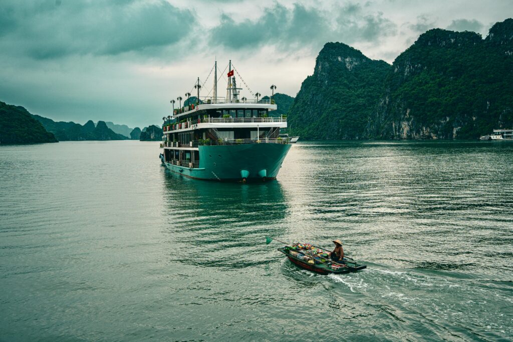 pexels-photo-27846404-27846404 Majestic cruise boat sailing through the emerald waters of Halong Bay, Vietnam, surrounded by limestone formations.