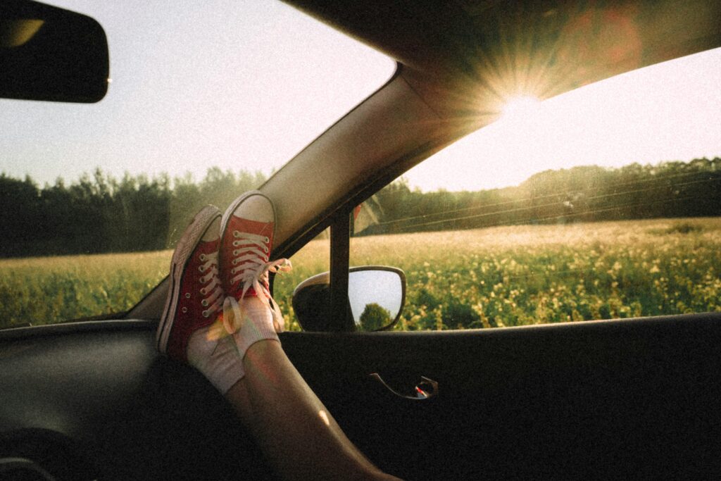 pexels-photo-2847037-2847037 Feet propped up on car dashboard with scenic countryside view during a sunny road trip.