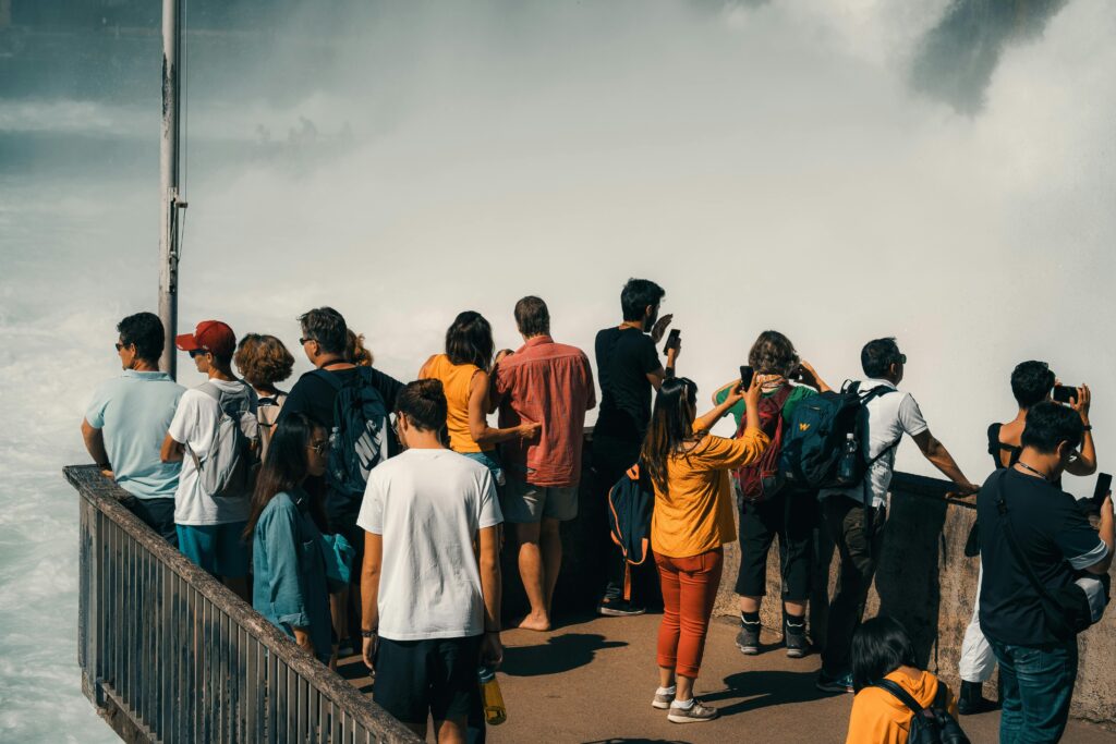 pexels-photo-2893294-2893294 Group of tourists capturing the majestic Rhine Falls from a viewing platform in Switzerland.