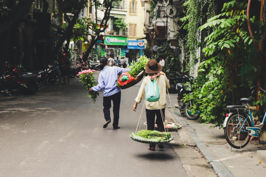 pexels-photo-2977382-2977382 Street vendors in Hanoi, Vietnam, selling fresh vegetables and flowers on a vibrant local street.