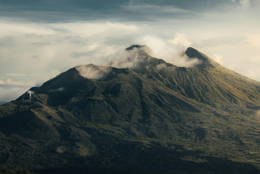 pexels-photo-3762284-3762284 A breathtaking aerial view of the majestic Mount Batur in Bali, shrouded in mist and clouds.