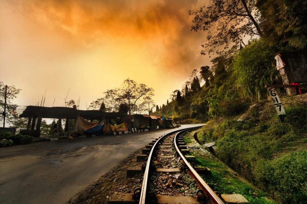 pexels-photo-3878609-3878609 Captivating railway curves through lush Darjeeling landscape at sunset, enhancing the dramatic sky.