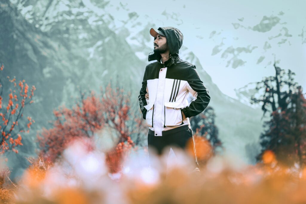 pexels-photo-6259173-6259173 A young man stands amidst vibrant autumn foliage in the Himalayas, showcasing adventure and exploration.