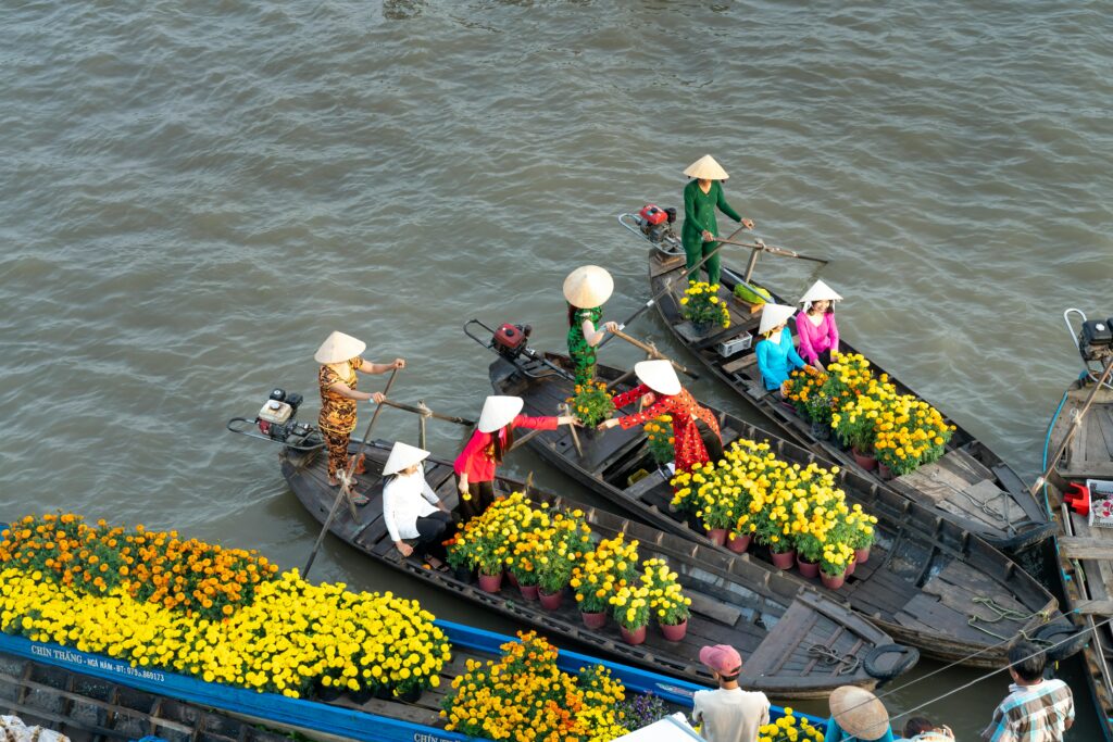 pexels-photo-6347165-6347165 Women selling flowers from rowboats at a vibrant floating market in Soc Trang, Vietnam.
