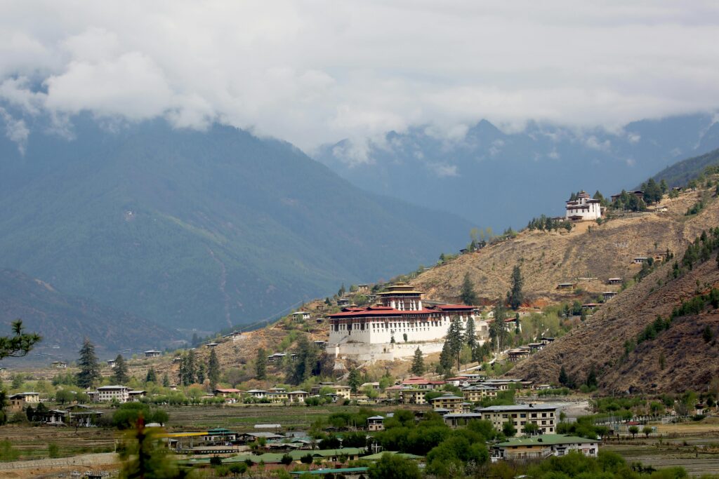 pexels-photo-7967949-7967949 Scenic view of Paro Valley with Rinpung Dzong, surrounded by mountains and clouds in Bhutan.