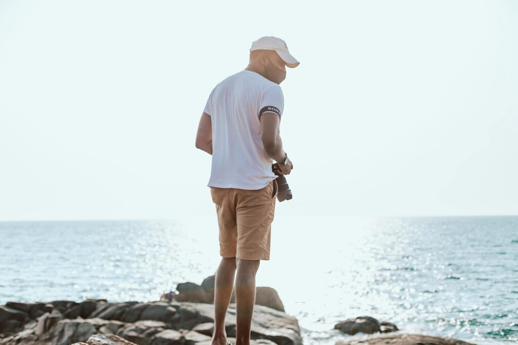 pexels-photo-8785678-8785678 A man walks along the rocky Balapitiya beach, capturing the seaside view.